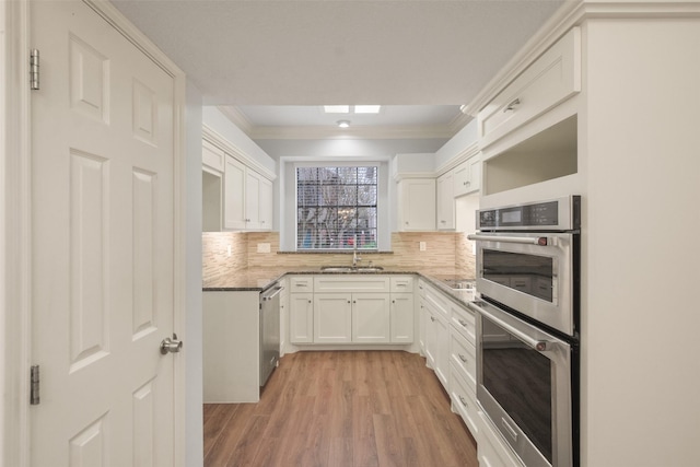 12859 Kingsbridge Ln, Houston, TX 77077 - kitchen featuring stainless steel appliances, light wood-style flooring, backsplash, crown molding, and light stone countertops