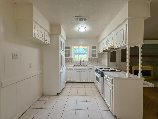 20 Woods Ln, Coldspring, TX 77331 - kitchen with white electric range, decorative backsplash, light countertops, a textured ceiling, and glass insert cabinets