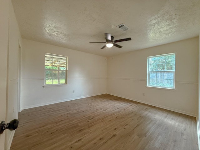 20 Woods Ln, Coldspring, TX 77331 - empty room with wood finished floors, plenty of natural light, a textured ceiling, and a ceiling fan