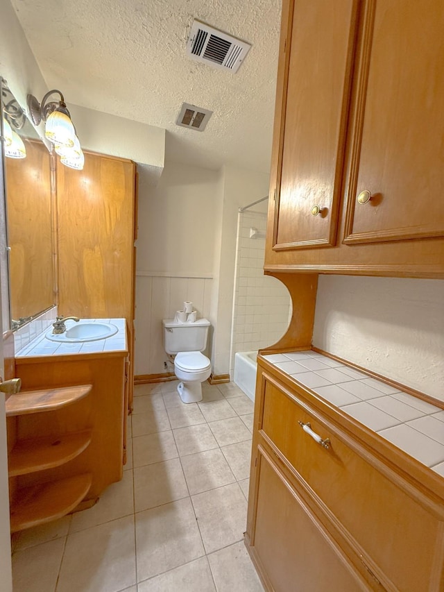 20 Woods Ln, Coldspring, TX 77331 - bathroom with vanity, washtub / shower combination, tile patterned floors, a textured ceiling, and wainscoting