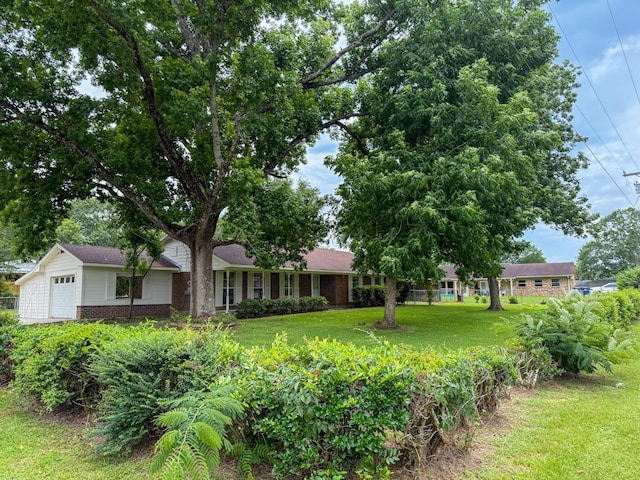 20 Woods Ln, Coldspring, TX 77331 - ranch-style house featuring brick siding, a front yard, and a garage