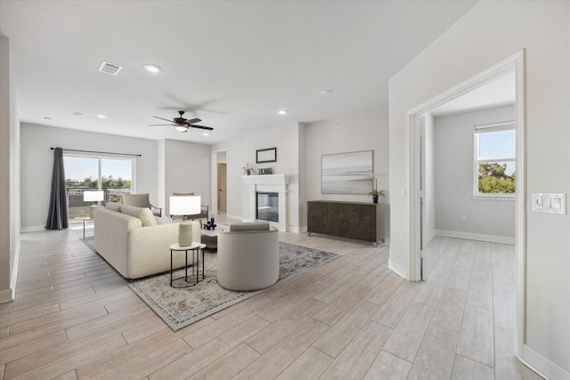 6804 Westview Dr Unit 1407, Houston, TX 77055 - living room featuring a ceiling fan, light wood finished floors, a glass covered fireplace, and recessed lighting