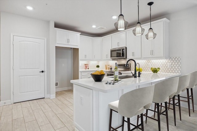 6804 Westview Dr Unit 1407, Houston, TX 77055 - kitchen featuring stainless steel appliances, a peninsula, backsplash, light countertops, and white cabinets