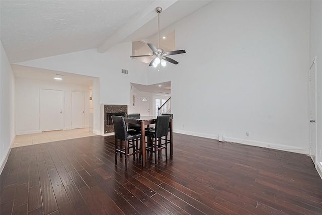 12230 Southmeadow Dr, Stafford, TX 77477 - dining space featuring wood-type flooring, ceiling fan, a fireplace, beamed ceiling, and stairway