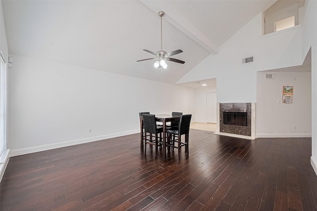 12230 Southmeadow Dr, Stafford, TX 77477 - dining area with ceiling fan, dark wood-type flooring, a premium fireplace, beam ceiling, and high vaulted ceiling