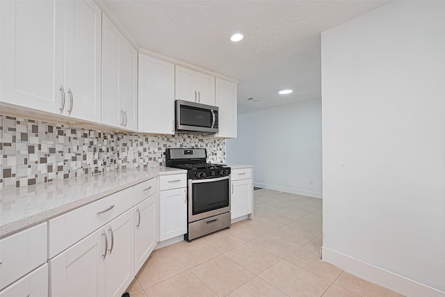 12230 Southmeadow Dr, Stafford, TX 77477 - kitchen with stainless steel appliances, decorative backsplash, white cabinets, light tile patterned flooring, and recessed lighting
