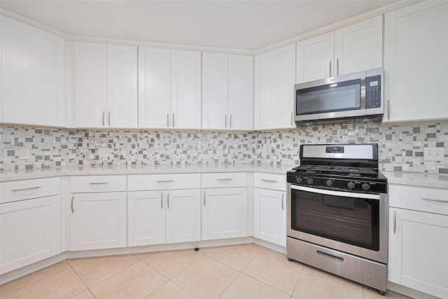 12230 Southmeadow Dr, Stafford, TX 77477 - kitchen with appliances with stainless steel finishes, light tile patterned floors, white cabinetry, and tasteful backsplash
