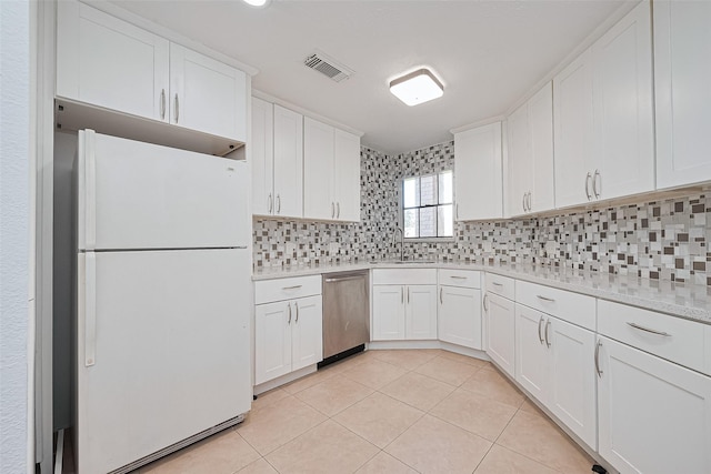 12230 Southmeadow Dr, Stafford, TX 77477 - kitchen featuring freestanding refrigerator, stainless steel dishwasher, decorative backsplash, and white cabinetry