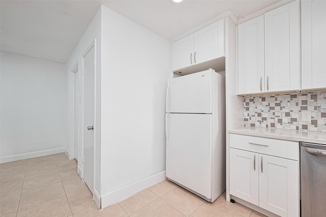 12230 Southmeadow Dr, Stafford, TX 77477 - kitchen with freestanding refrigerator, stainless steel dishwasher, decorative backsplash, light tile patterned floors, and white cabinetry