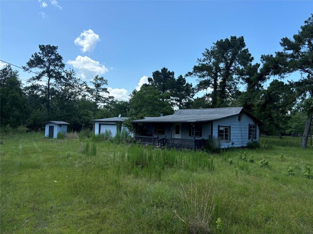 2736 Whitetail Forest Rd, Kountze, TX 77625 - view of front facade with a shed, covered porch, and a garage