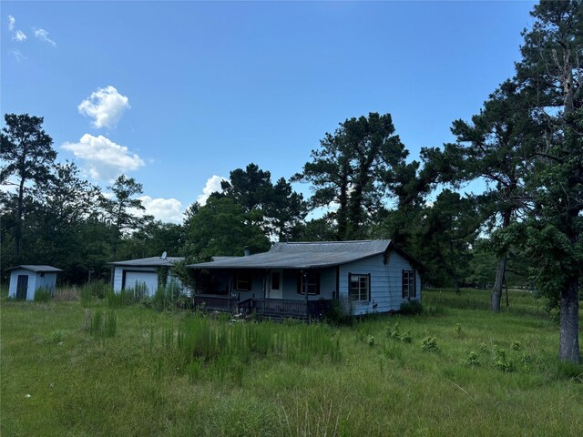 2736 Whitetail Forest Rd, Kountze, TX 77625 - view of front facade featuring covered porch, a storage unit, and a garage