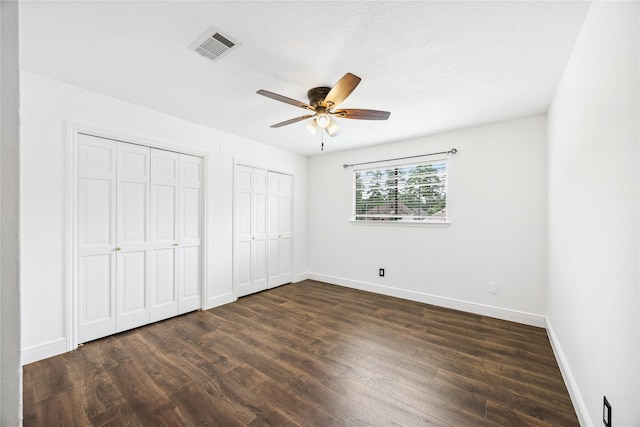 12414 Laneview Dr, Houston, TX 77070 - unfurnished bedroom with multiple closets, dark wood-type flooring, and ceiling fan