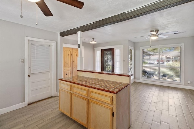 3520 Mattye Maye Dr, Pasadena, TX 77503 - kitchen featuring a ceiling fan, tile countertops, light wood finished floors, light brown cabinets, and open floor plan