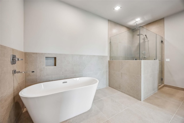 1111 W 21st St, Houston, TX 77008 - bathroom with tile walls, a stall shower, a freestanding bath, and tile patterned floors