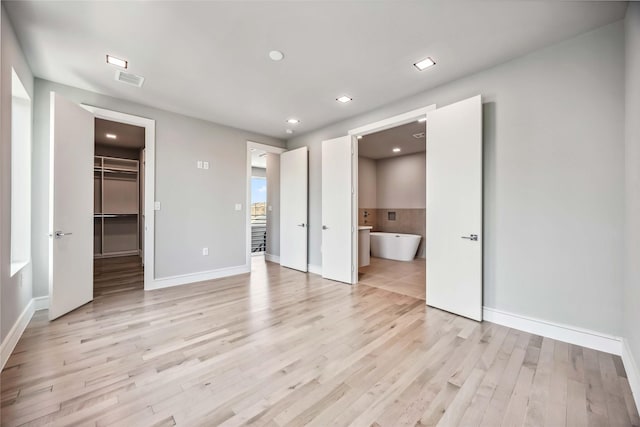 1111 W 21st St, Houston, TX 77008 - unfurnished bedroom featuring light wood-style floors, a spacious closet, recessed lighting, and connected bathroom