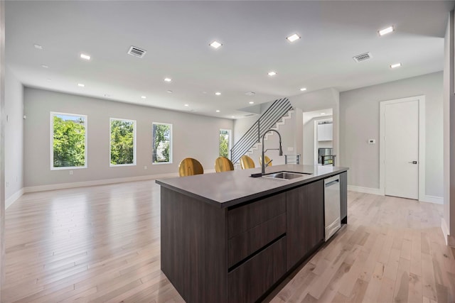 1111 W 21st St, Houston, TX 77008 - kitchen with modern cabinets, an island with sink, dark brown cabinetry, light wood-type flooring, and recessed lighting
