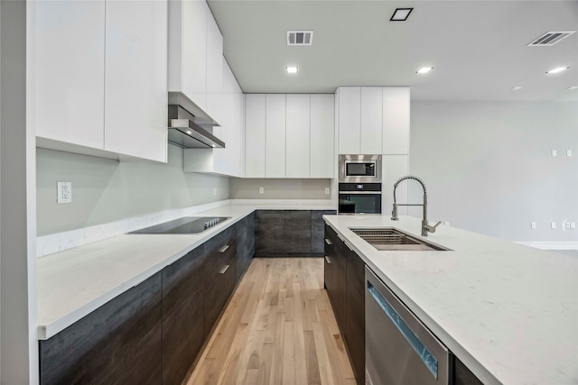 1111 W 21st St, Houston, TX 77008 - kitchen with modern cabinets, appliances with stainless steel finishes, dark brown cabinetry, light wood-style floors, and white cabinetry