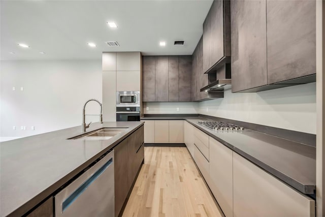 1111 W 21st St, Houston, TX 77008 - kitchen with stainless steel appliances, modern cabinets, light wood-style flooring, dark countertops, and recessed lighting