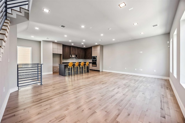 1111 W 21st St, Houston, TX 77008 - living room featuring recessed lighting, light wood-type flooring, and stairs
