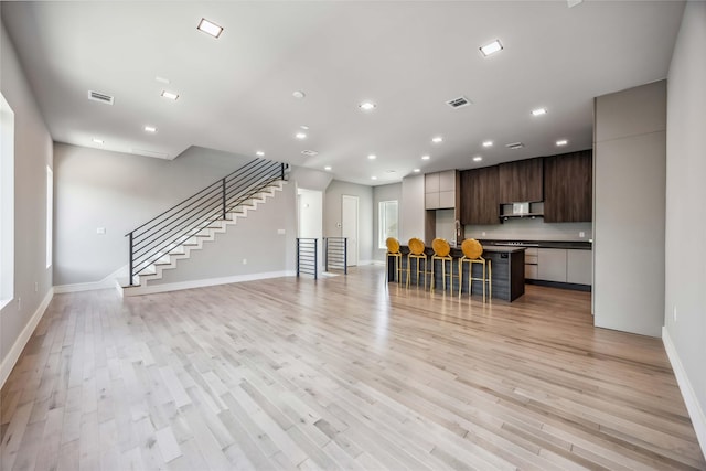 1111 W 21st St, Houston, TX 77008 - living area featuring light wood finished floors, recessed lighting, and stairs
