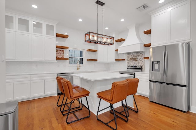 630 S Railroad Ave, Shepherd, TX 77371 - kitchen with stainless steel appliances, open shelves, custom exhaust hood, light countertops, and recessed lighting