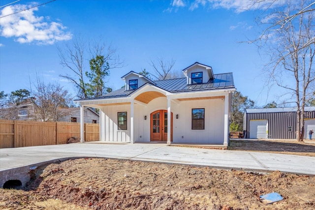 630 S Railroad Ave, Shepherd, TX 77371 - modern farmhouse featuring a standing seam roof, board and batten siding, a porch, a metal roof, and french doors
