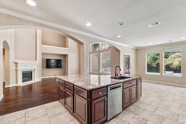 15602 Shining Brook Ct, Houston, TX 77044 - kitchen featuring stainless steel dishwasher, ornamental molding, open floor plan, light stone countertops, and a glass covered fireplace