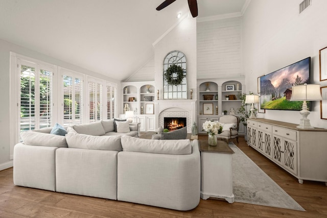 13306 Golden Valley Dr, Cypress, TX 77429 - living area featuring high vaulted ceiling, a ceiling fan, built in features, a large fireplace, and wood finished floors