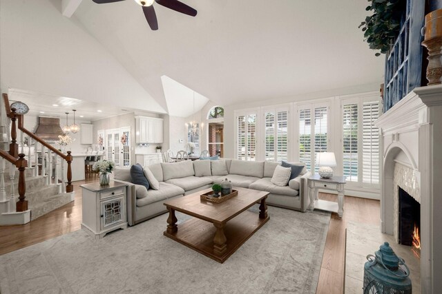 13306 Golden Valley Dr, Cypress, TX 77429 - living area featuring a premium fireplace, a chandelier, stairs, high vaulted ceiling, and a ceiling fan