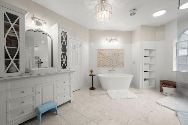 13306 Golden Valley Dr, Cypress, TX 77429 - full bath featuring vanity, a freestanding tub, tile walls, and a chandelier