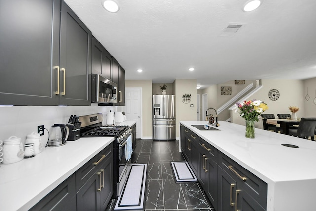 19110 Remington Springs Dr, Houston, TX 77073 - kitchen featuring stainless steel appliances, dark marble finish floors, recessed lighting, light countertops, and a kitchen island with sink