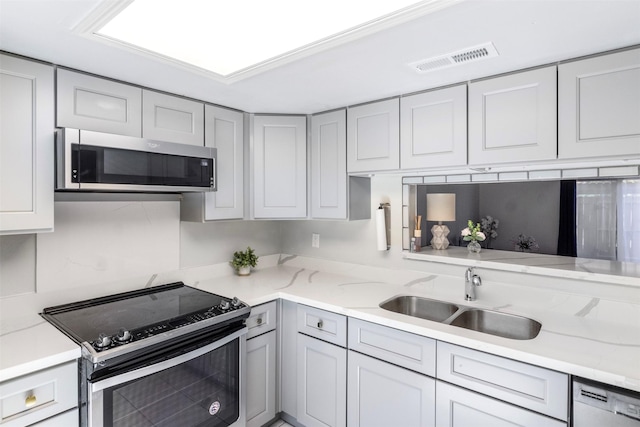 14333 Memorial Dr Unit 44, Houston, TX 77079 - kitchen featuring appliances with stainless steel finishes, gray cabinets, and light stone counters