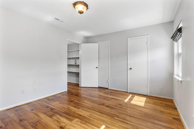 14333 Memorial Dr Unit 44, Houston, TX 77079 - unfurnished bedroom with wood finished floors and multiple closets