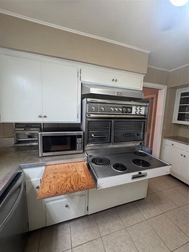 524 Oak Dr, Lake Jackson, TX 77566 - kitchen featuring appliances with stainless steel finishes, light tile patterned flooring, crown molding, and white cabinetry