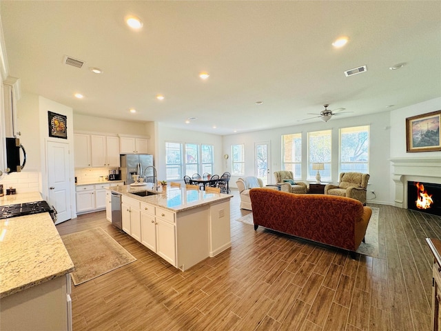 11119 Alpenhorn Pl, Tomball, TX 77375 - kitchen featuring stainless steel appliances, recessed lighting, white cabinets, backsplash, and wood finished floors