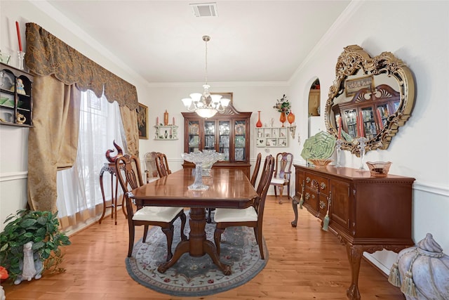 16535 Mccormick Dr, Houston, TX 77095 - dining space featuring a chandelier, light wood-type flooring, crown molding, and arched walkways