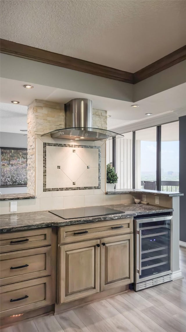 5001 Woodway Dr Unit 1704, Houston, TX 77056 - bar area featuring wine cooler, island exhaust hood, crown molding, black electric cooktop, and decorative backsplash