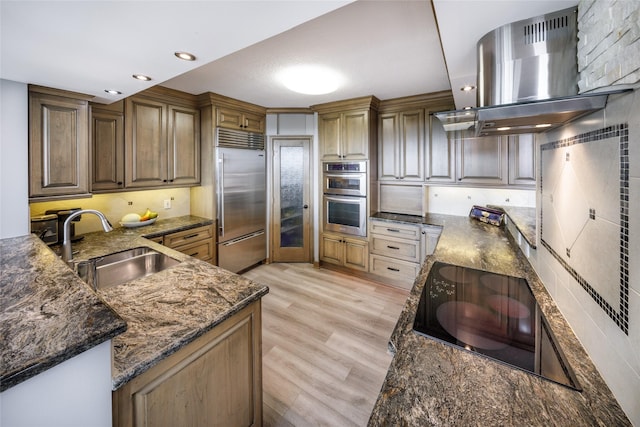 5001 Woodway Dr Unit 1704, Houston, TX 77056 - kitchen featuring stainless steel appliances, island range hood, dark stone countertops, light wood-style flooring, and recessed lighting