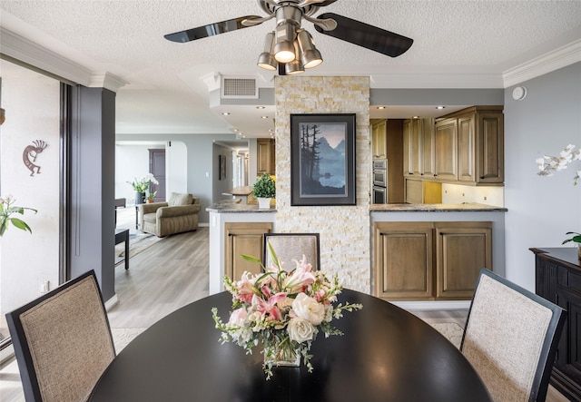 5001 Woodway Dr Unit 1704, Houston, TX 77056 - dining space with ceiling fan, crown molding, a textured ceiling, and light wood-style flooring