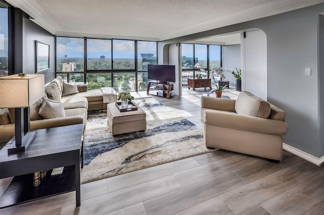 5001 Woodway Dr Unit 1704, Houston, TX 77056 - living room with wood finished floors, a textured ceiling, floor to ceiling windows, and arched walkways