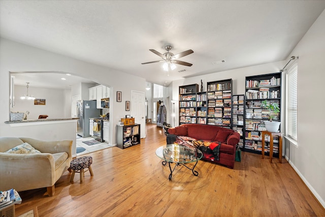 14711 Trailbrook Dr, Houston, TX 77095 - living room with arched walkways, light wood-style floors, and ceiling fan
