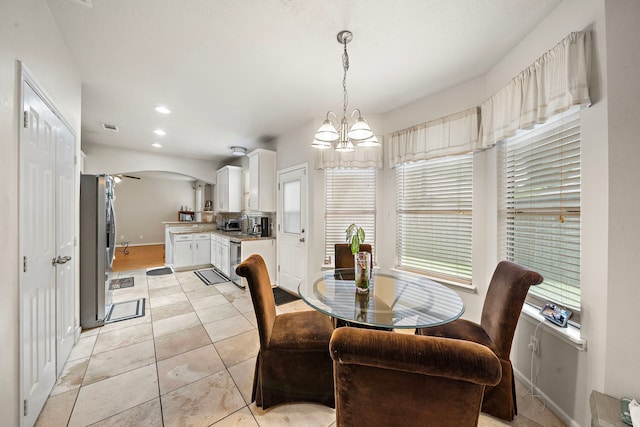 14711 Trailbrook Dr, Houston, TX 77095 - dining area with plenty of natural light, a chandelier, arched walkways, light tile patterned flooring, and recessed lighting