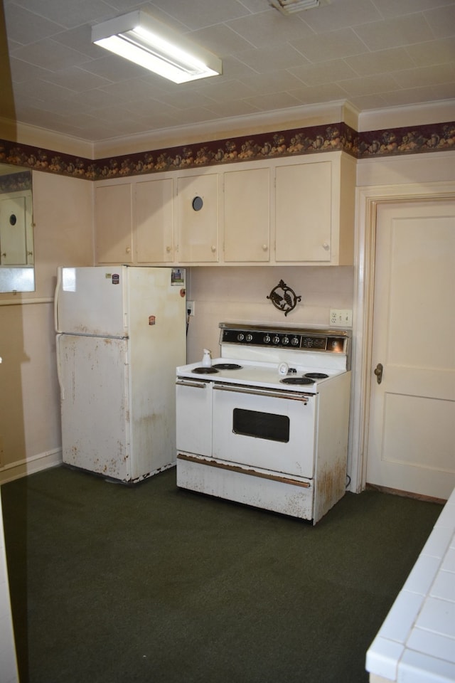 801 Erin St, El Campo, TX 77437 - kitchen with white appliances, tile countertops, ornamental molding, white cabinets, and dark colored carpet