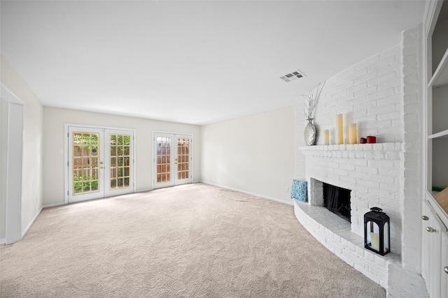 14708 Perthshire Rd Unit F, Houston, TX 77079 - unfurnished living room featuring a brick fireplace, carpet flooring, and french doors