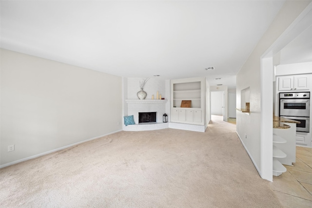 14708 Perthshire Rd Unit F, Houston, TX 77079 - unfurnished living room featuring light colored carpet and a brick fireplace