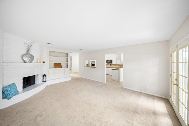14708 Perthshire Rd Unit F, Houston, TX 77079 - unfurnished living room with light colored carpet, built in features, and a brick fireplace