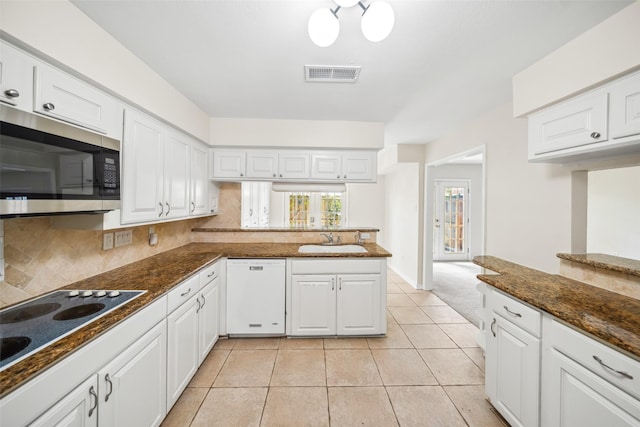 14708 Perthshire Rd Unit F, Houston, TX 77079 - kitchen with dishwasher, stainless steel microwave, electric stovetop, white cabinets, and tasteful backsplash