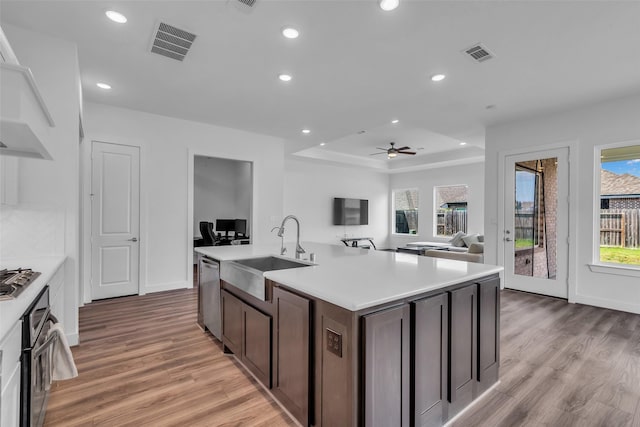 10614 Hazel Hills Dr, Cypress, TX 77433 - kitchen with stainless steel appliances, light countertops, light wood finished floors, recessed lighting, and dark brown cabinets