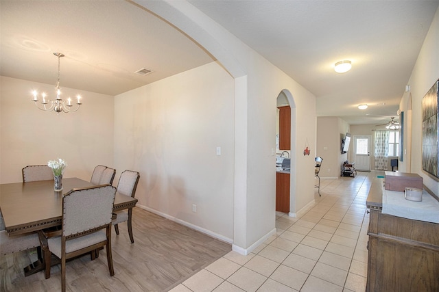 1911 Vineyard Bend Ct, Pearland, TX 77581 - dining area featuring arched walkways, a chandelier, light tile patterned floors, and a ceiling fan