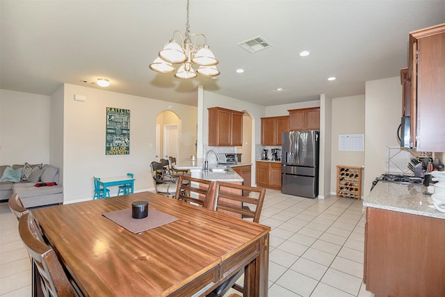 1911 Vineyard Bend Ct, Pearland, TX 77581 - dining room with arched walkways, a chandelier, light tile patterned floors, and recessed lighting
